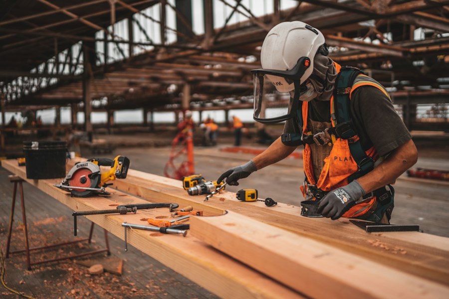 A carpenter measuring lumber on a job site