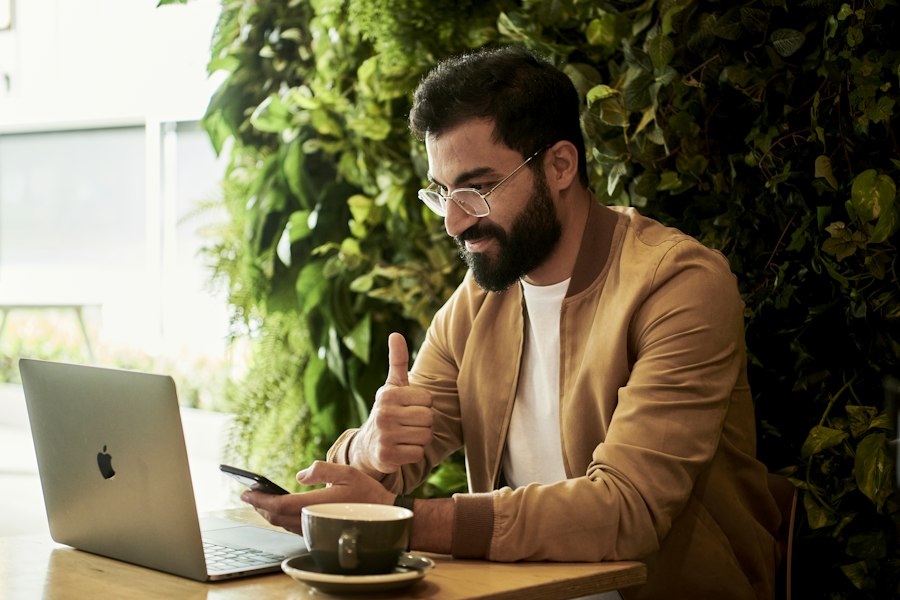 A business owner giving a thumbs up at his laptop